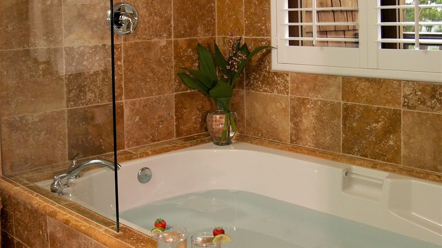 A bathroom featuring a soaking tub and rustic tiles - Brewery Gulch Inn & Spa