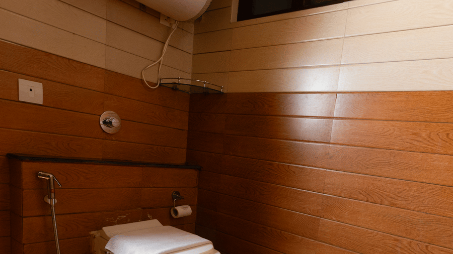 Modern bathroom at Sumitel Hotels designed with wooden panel walls, a wall-mounted toilet, contemporary fittings, clean lines, bright lighting, and premium hotel-style amenities.