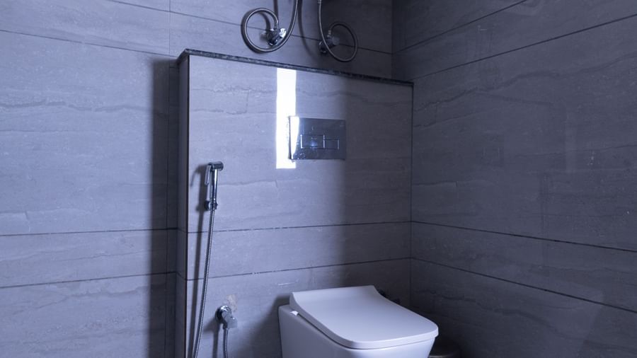 Bathroom at Sumitel Premier Inn, Siliguri, featuring tiled walls, a mounted flush, and simple modern fittings for guest convenience and hygiene.