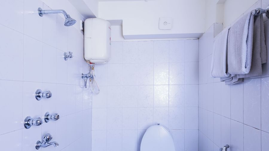 Bathroom at Sumitel Premier Inn, Siliguri, with a modern WC, shower area, water heater, and clean tiling, ensuring comfort and convenience for guests.