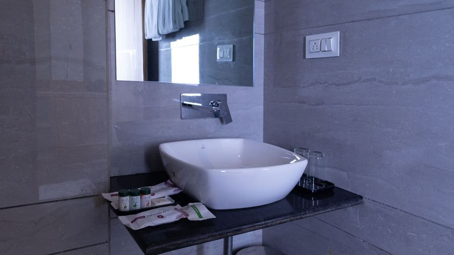 Washroom at Sumitel Premier Inn, Siliguri, featuring a sleek basin, mirror, and polished interiors designed with a minimalist and functional style.