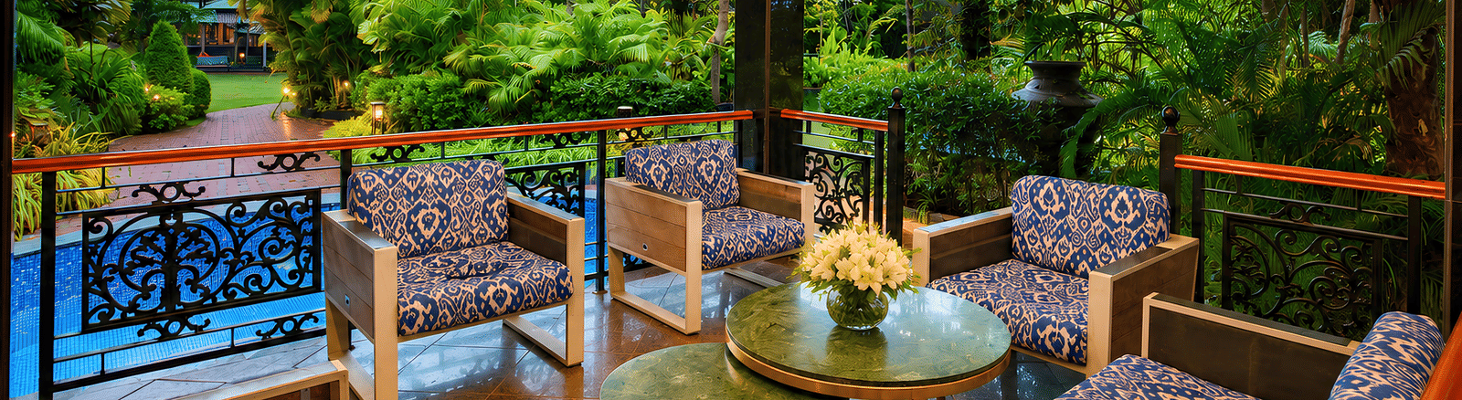 Gazebo seating with blue ikat armchairs, green marble tables and fretwork arches overlooking the pool and garden at MAYFAIR Oasis Resort & Convention, Jharsuguda.