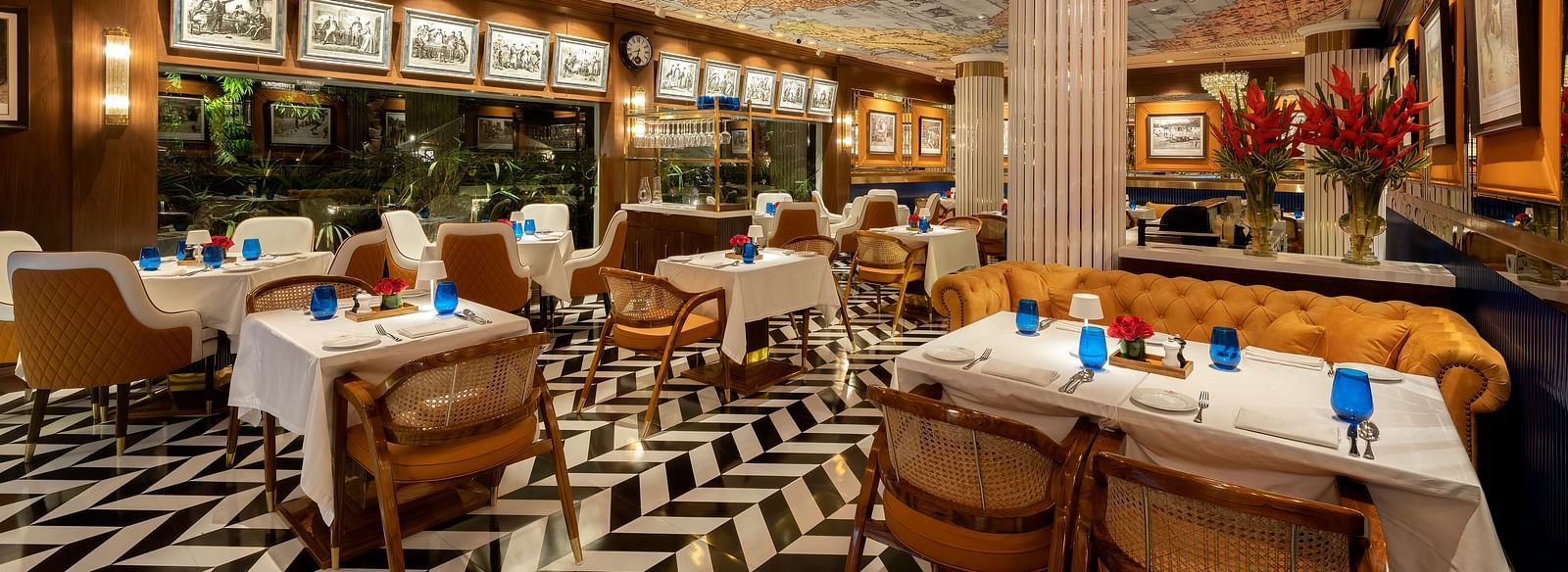image of the pickwick multi cuisine restaurant in delhi with stunning interiors and a ceiling with a world map - The Claridges New Delhi