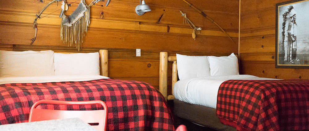 A wooden cabin with twin beds at Shaver Lake Village Hotel.