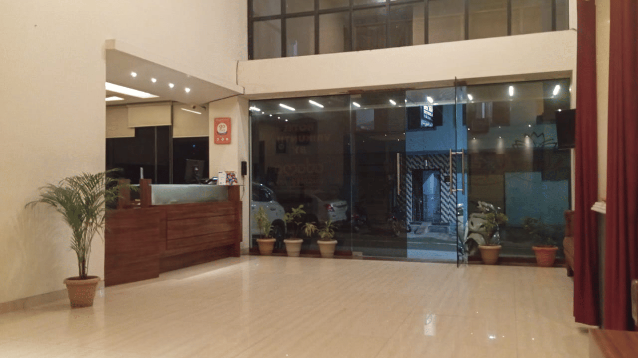 Spacious hotel lobby and reception desk area featuring a polished floor and glass entrance doors.