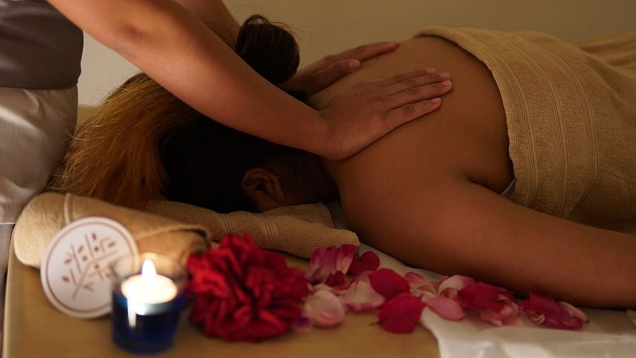 A person lying on their back with their face on a towel getting a back massage