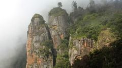 A far-out view of Pillar Rocks on a foggy day with vegetation around, a must-visit on a 2-Day Trip to Kodaikanal