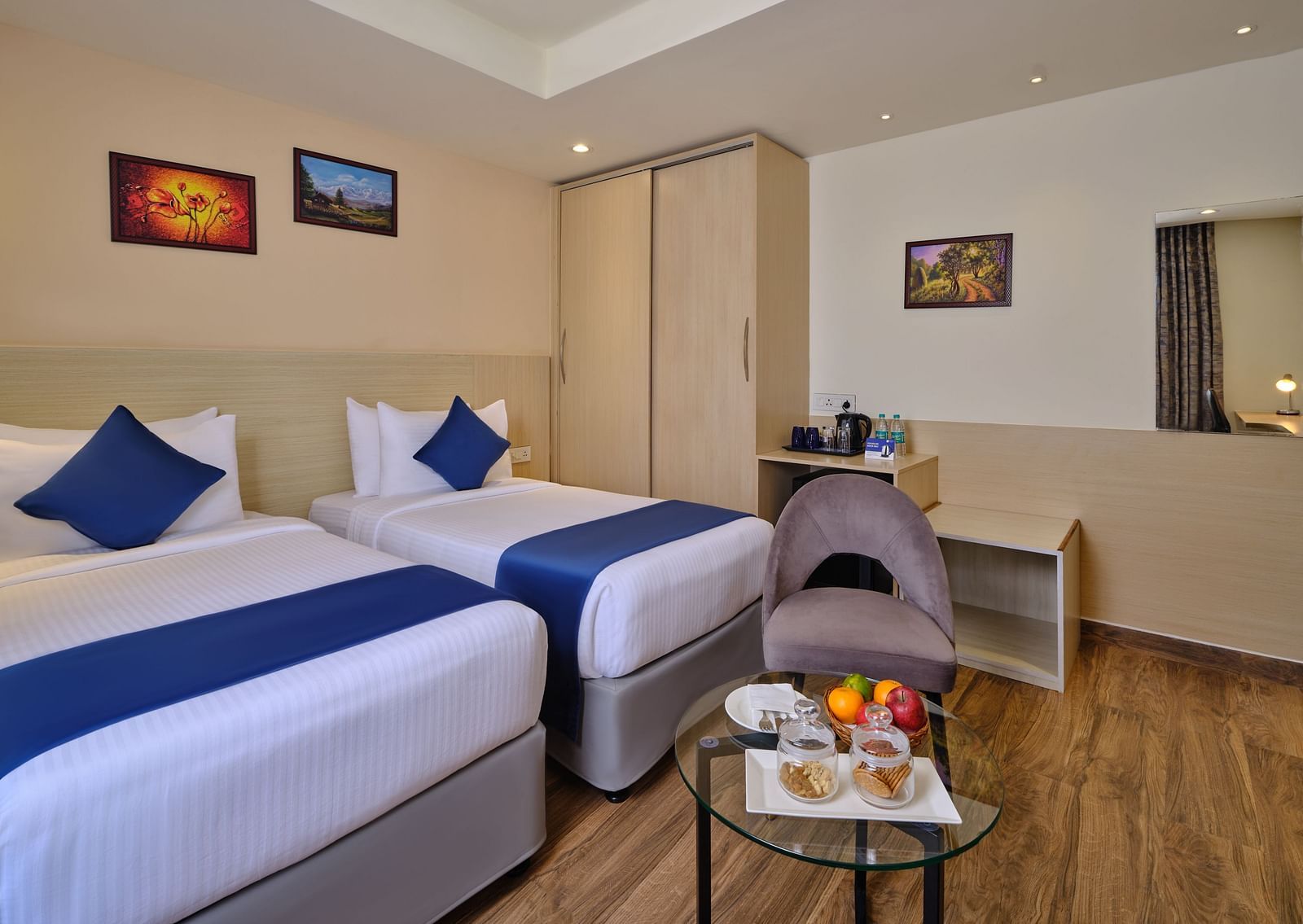 A room at Essentia Premier Hotel, Chennai with twin beds, a wardrobe and a coffee table