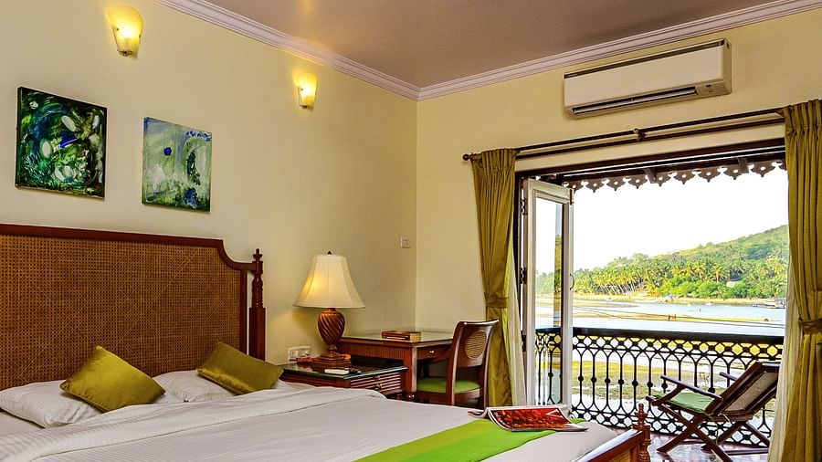 A double bed ac study table and chair inside Coral - River View room at neemrana s three waters