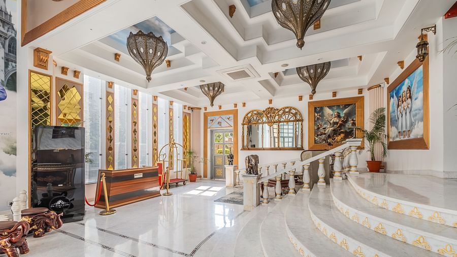 Hotel interiors with steps leading upstairs and dome shaped chandeliers hanging fromtheceiling