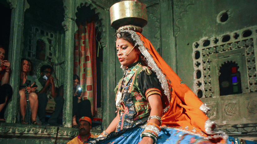 a cultural performance by a woman inside bagore ki haveli.