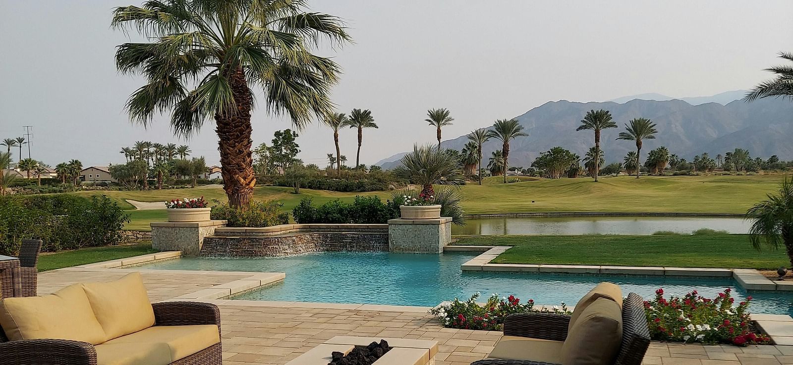 A beautiful landscape with a swimming pool along with a mountain range in the background.