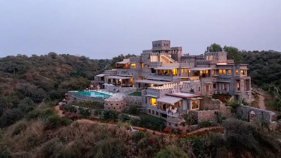 Facade image of Chunda Shikhar Oudi Jaipur placed on a small hill with forest cover