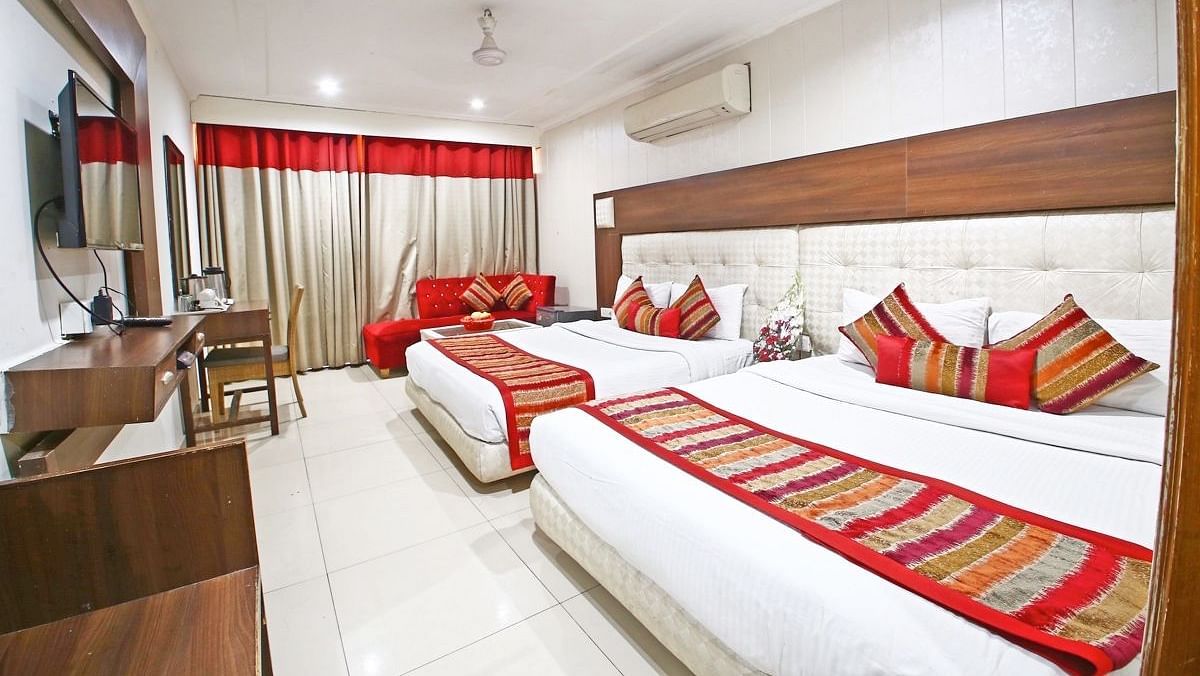 Family Room featuring a work desk, large window with curtains, and two queen size beds -  Hotel Diamond Plaza, Chandigarh.