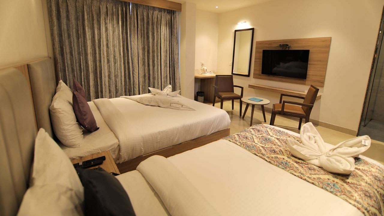 Room at Hotel Mumbai House Express, Udaipur with twin beds and a television