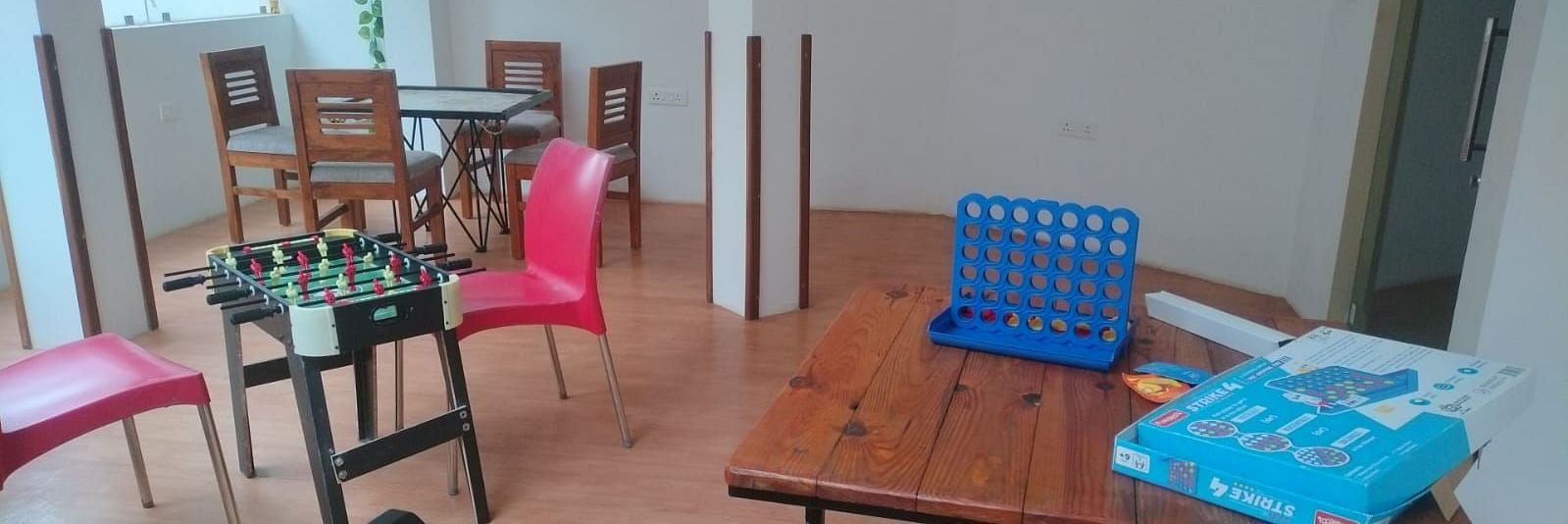 Indoor games room with chairs and a Connect Four game on the table at The Verda de Miranda Resort.