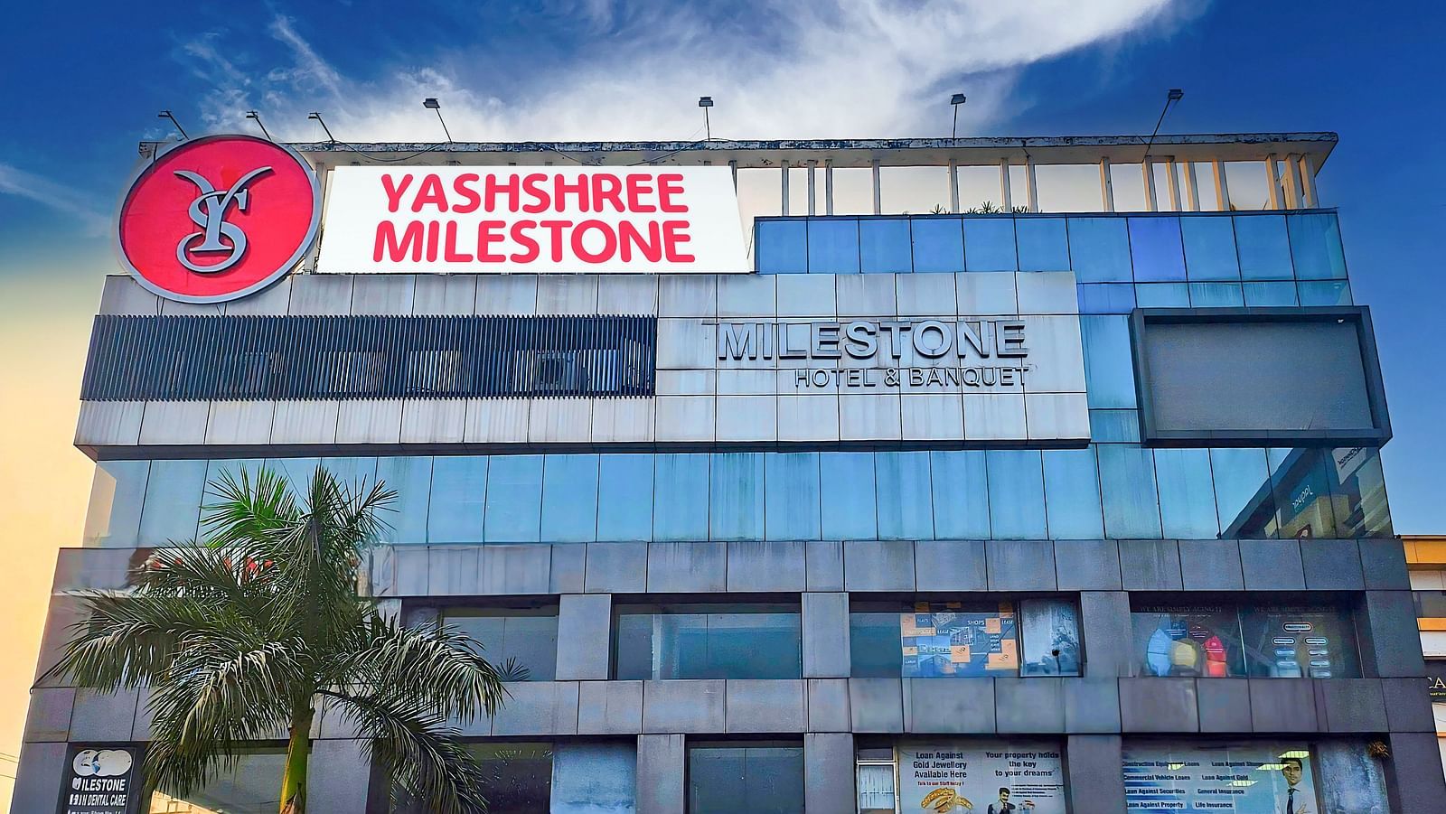 A facade image of Yashshree Milestone, Siliguri with the backdrop of the sky during dusk