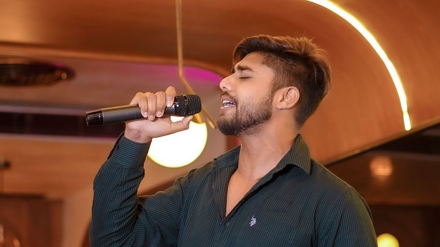 An image of a man speaking on a mic at Themis Barbecue House, Panipat
