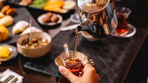 man pours teafrom tea-pot into armudu glass