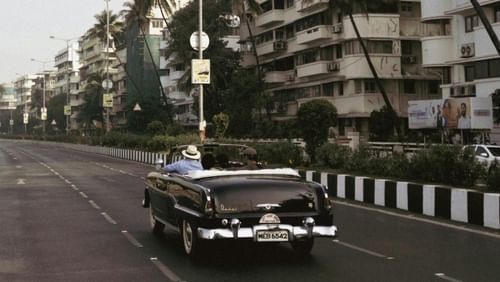 A view of a black car on a road. 