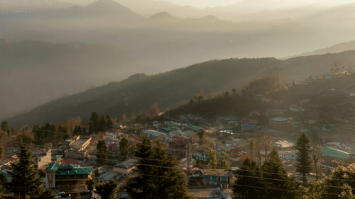 an aerial view of the town of Munsiyari in Uttarakhand with mountains in the background