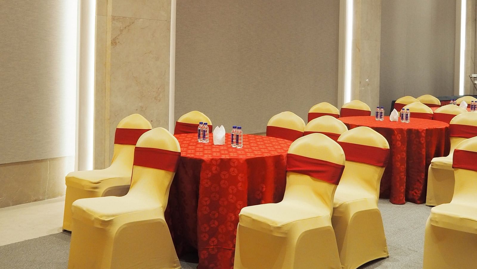 A close-up of a round table with chairs in a bright, modern hall - Club Charholi, Pune 