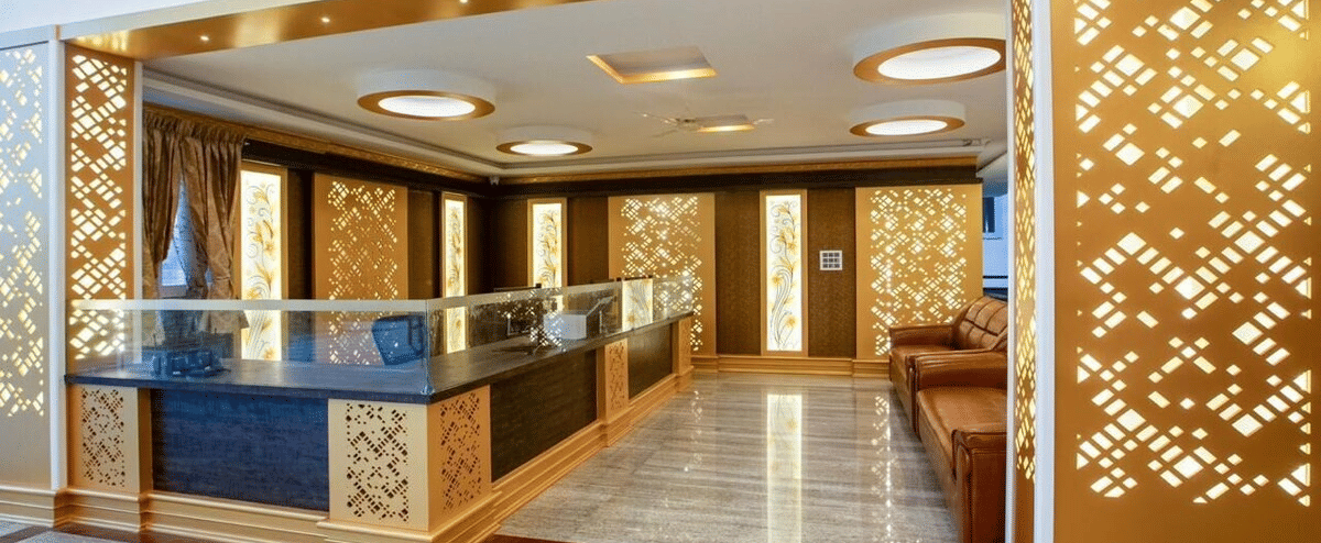 Stylish reception area with golden panelling and modern ceiling lights at Siri Ambari Resorts and Spa.