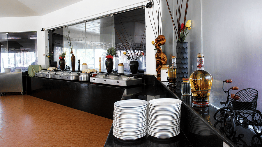 Kapi Multicuisine Restaurant buffet counter with chafing dishes and decorative accents, offering a warm and inviting dining setup