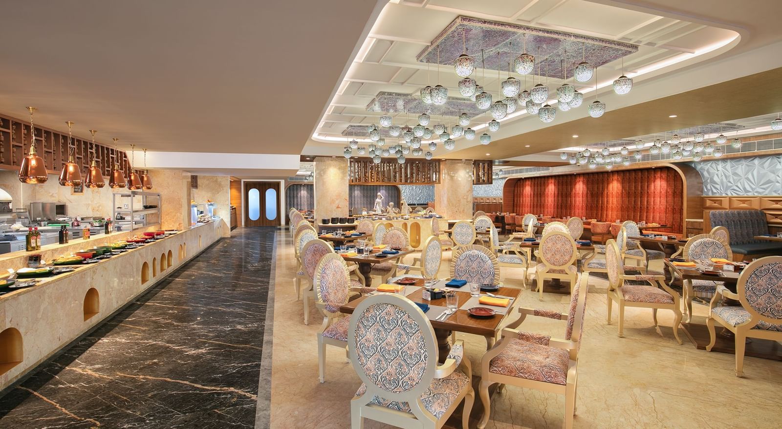 A lavish buffet area with artistic ceiling designs and refined seating arrangements at our restaurant in Mahabalipuram - Kaldan Samudhra Palace