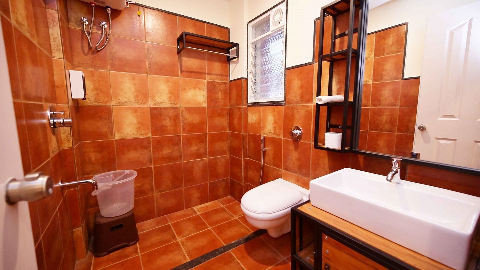A well-appointed bathroom at Forest Escapes Koyna includes a bathtub and tiled walls.