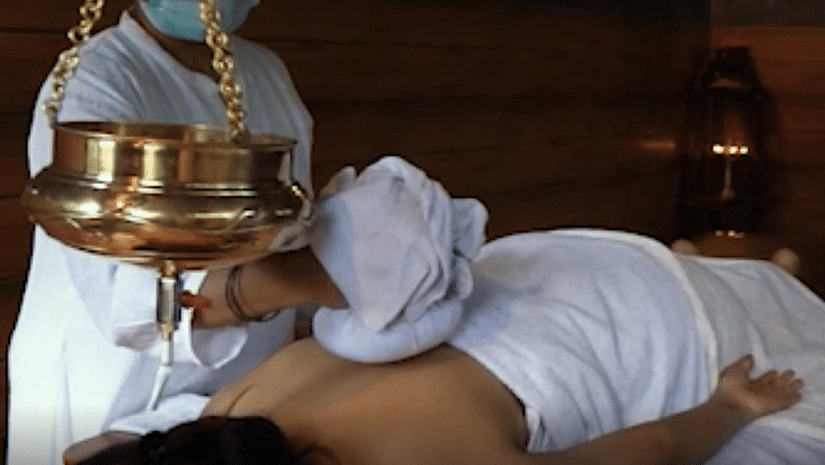 a person getting an ayurvedic massage by a masseuse - Holistic Stay Eco Resort, Kannur