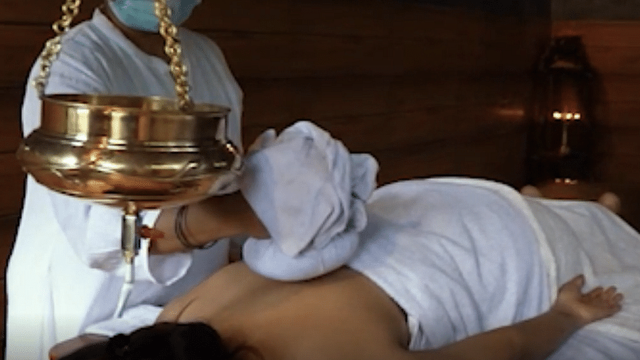 a person getting an ayurvedic massage by a masseuse - Holistic Stay Eco Resort, Kannur