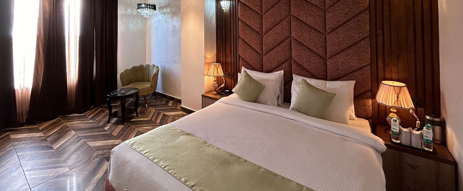 Image of Super Deluxe Room featuring a double bed with a nightstand next to it  as the sunlight makes its way into the room through the curtains - DLS Grand Luxotica, Dehradun