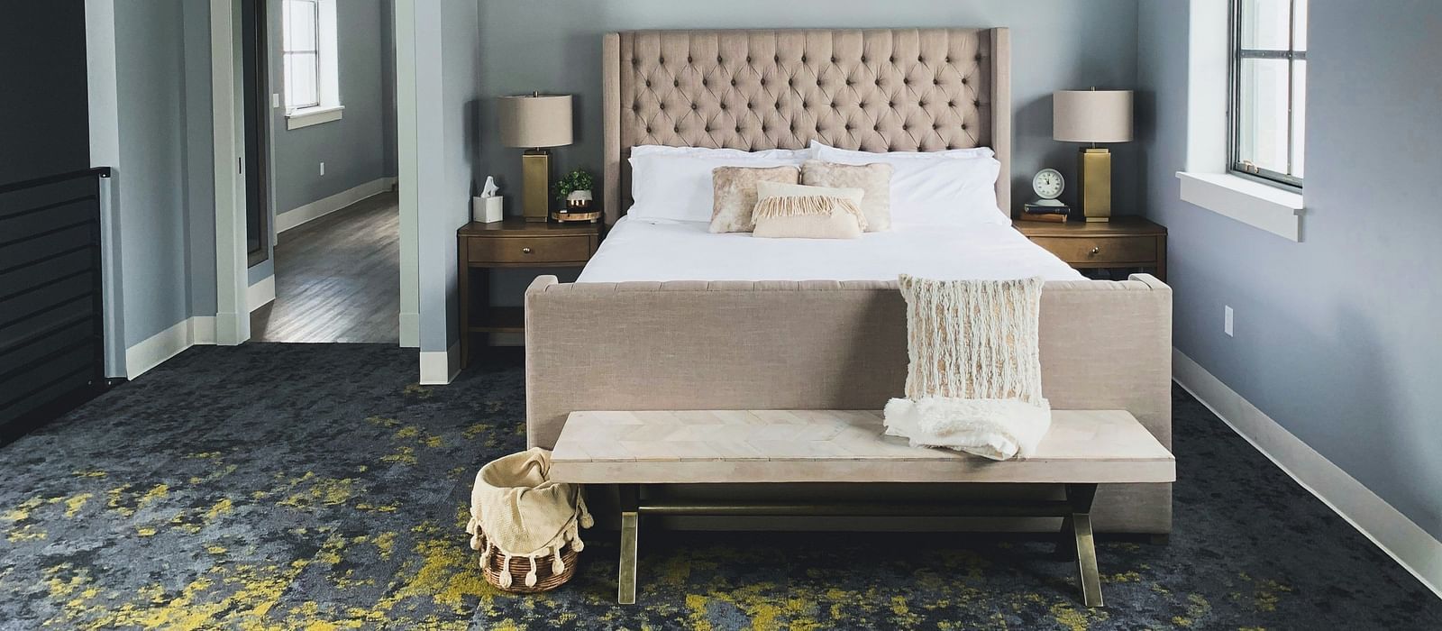 Image of a room with a double bed and a couch in front of it