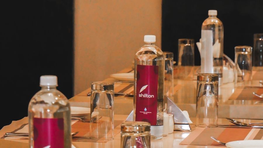 A neatly set conference table with water bottles and glasses, ready for a professional meeting at Shilton Dee Cee.