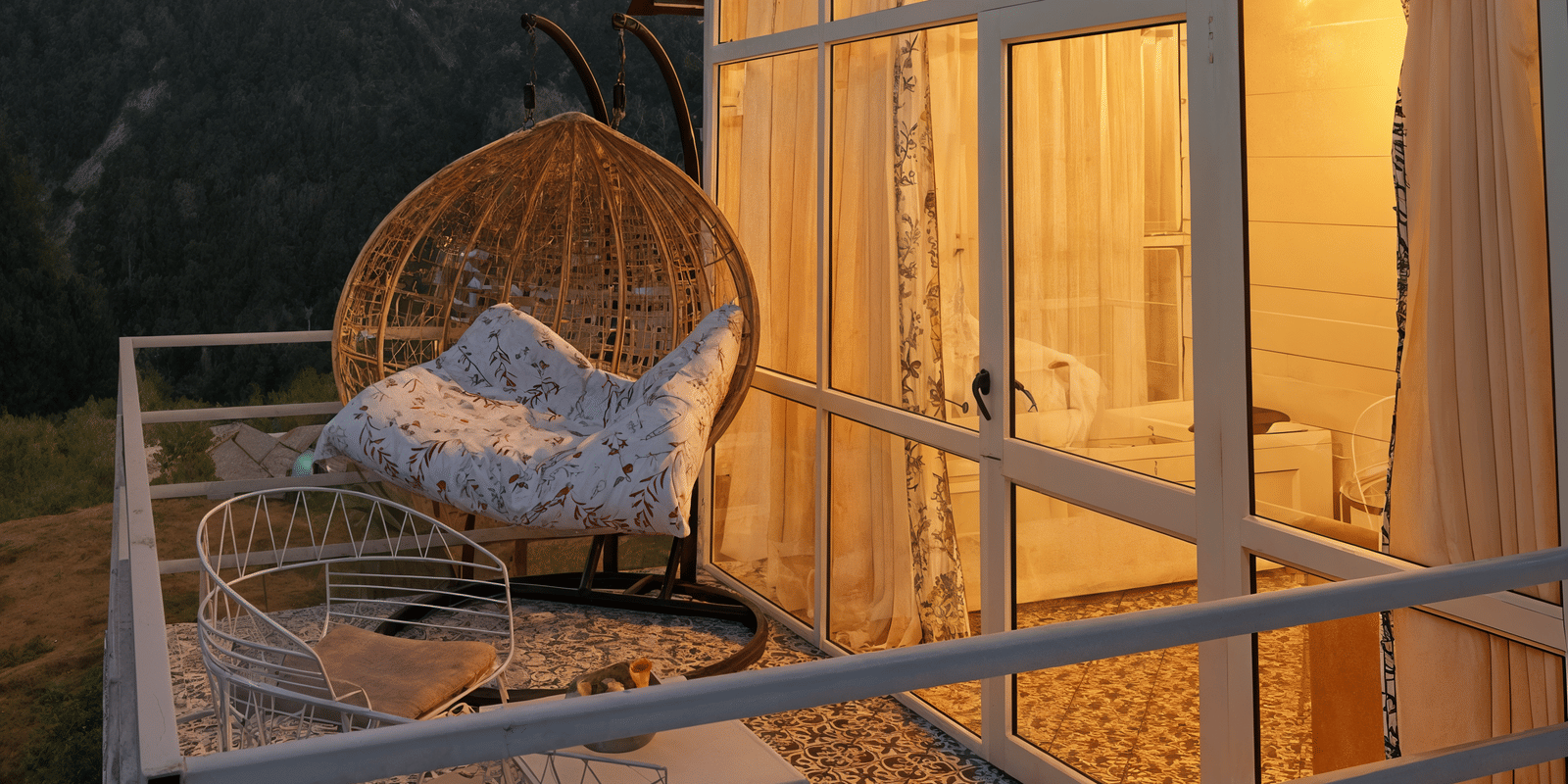 Balcony swing chair overlooking forested Dalhousie hills, part of the Luxe Cottage view at Nazaara Nature Retreat.