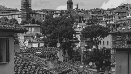 City street with houses with clouds in the background in a black and white image