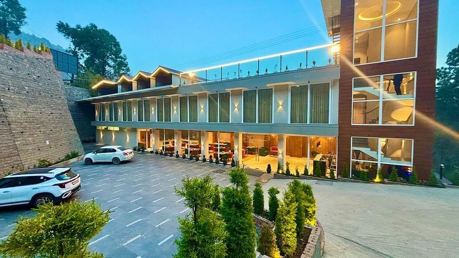 Exterior view of the ARNISA Boutique Hotel building with glass facade and neatly landscaped driveway