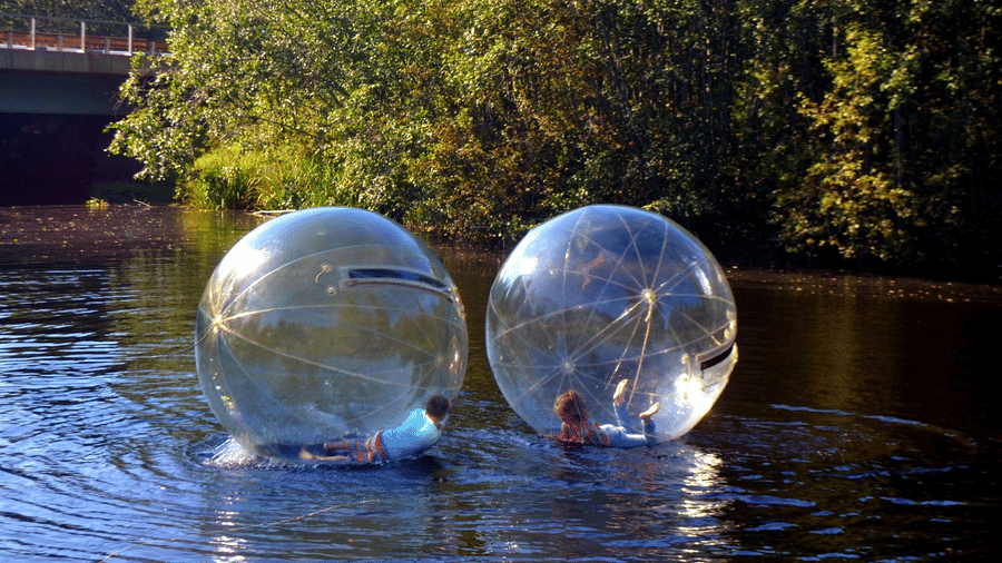two people Aqua zorbing on a lake 