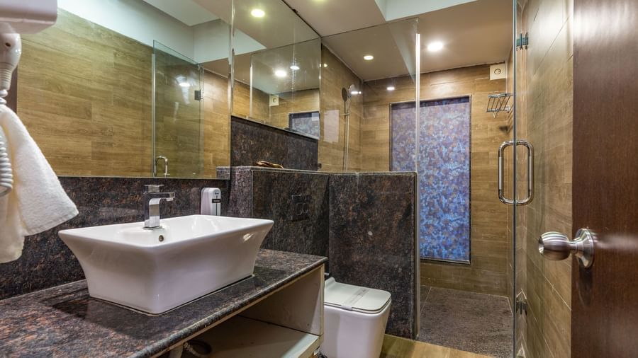 Bathroom of the Premium Room at Amara Oceanfront Resort, Baga, featuring a sink, and a separate shower area.