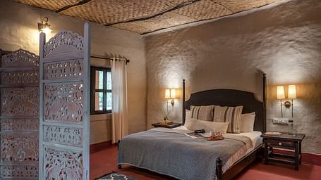 King size bed in Mud House Suite at Saccharum Safari Lodge, Balaghat
