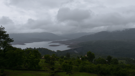 View of Koyna Dam, surrounded by misty mountains.
