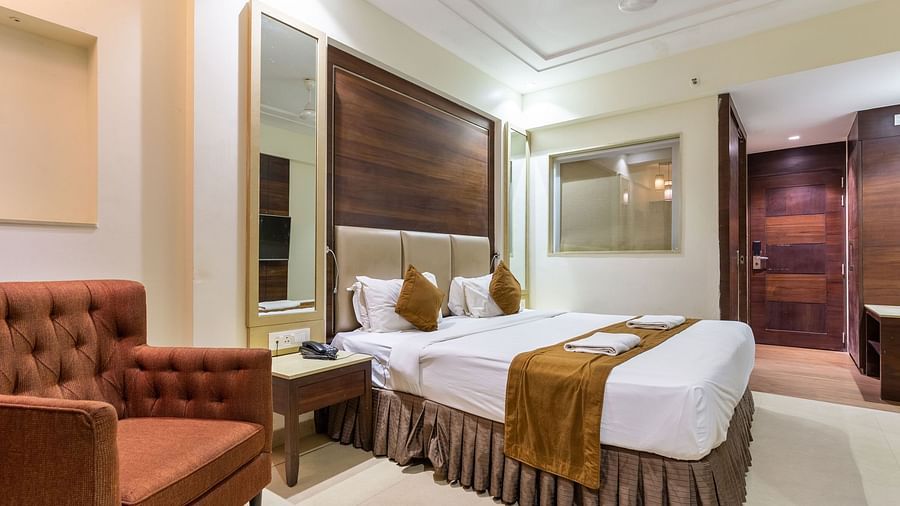 Image of a room with a bed and a sofa on the side at Calux Grand Inn, Calangute.