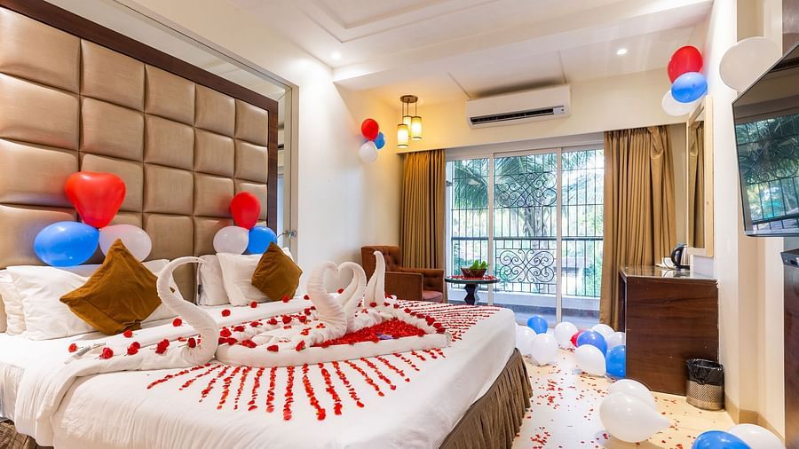 Image of a room decorated with balloons and flower petals at Calux Grand Inn, Calangute.