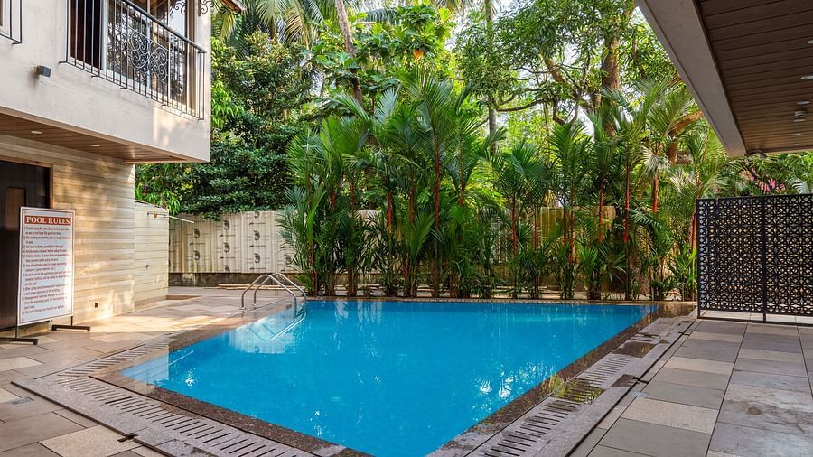 Image of a swimming pool with trees in the background at Calux Grand Inn, Calangute.