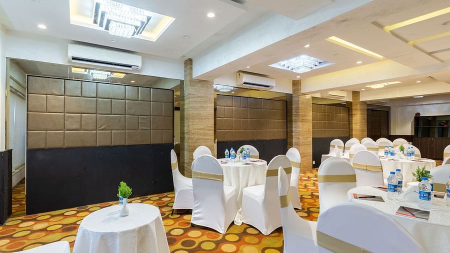 Image of a banquet hall with circular tables and chairs around it at Calux Grand Inn, Calangute.
