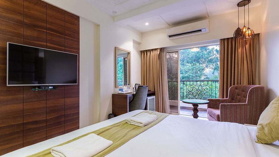 Image of a room with a bed and a television in front at at Calux Grand Inn, Calangute.