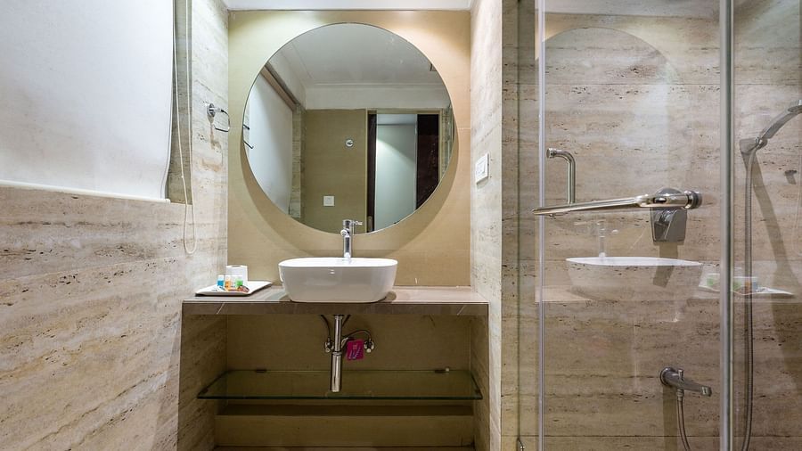 Image of a washroom with a mirror above the sink at Calux Grand Inn, Calangute.
