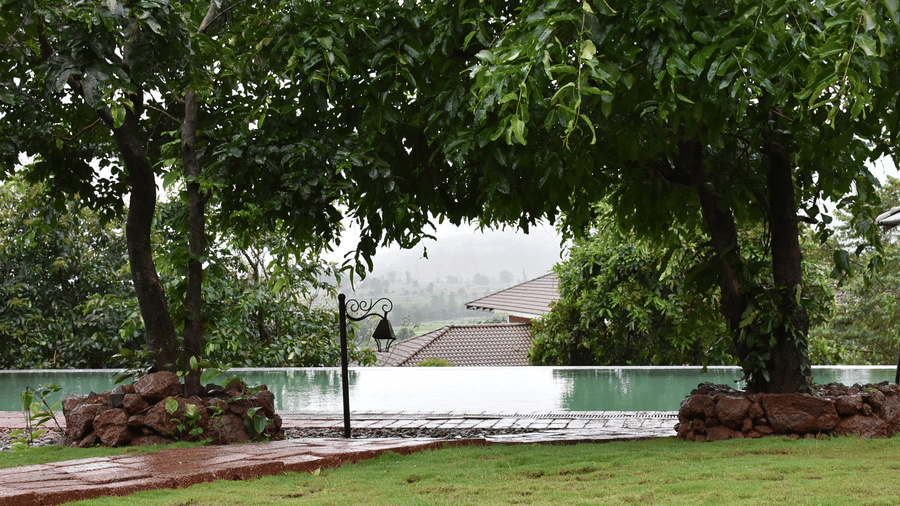A tranquil outdoor space at Forest Escapes Koyna with a pond or water feature surrounded by lush greenery.