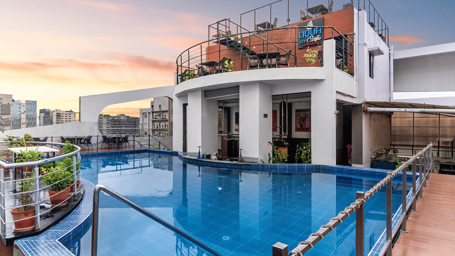 Full view shot of our rooftop swimming pool protected with railings with a beautiful sunset sky in the background - Senses Hotel